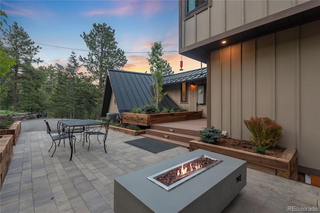 1298 Meadow View Dr, Evergreen, CO 80439 - patio terrace at dusk featuring a fire pit, a patio area, and outdoor dining area