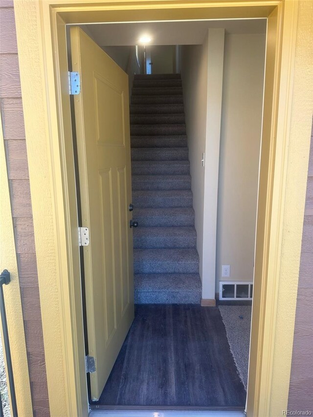 staircase with dark carpet