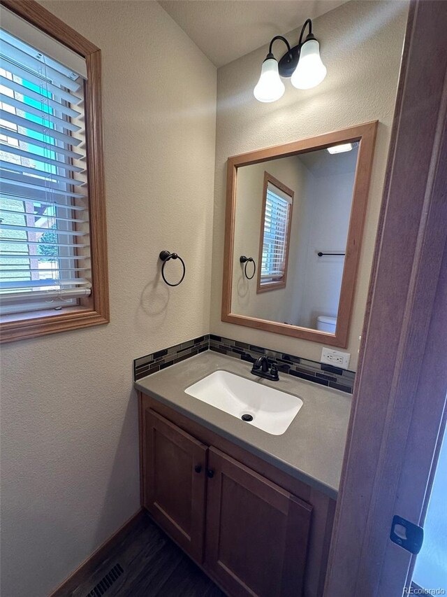 119 Edgewater Cir, Granby, CO 80446 - bathroom featuring toilet, backsplash, wood finished floors, vanity, and a textured wall