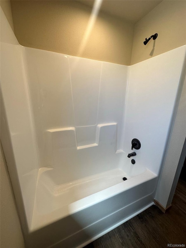 bathroom with hardwood / wood-style flooring and shower / bathing tub combination