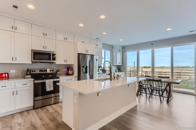 6645 Dry Fork Dr, Frederick, CO 80516 - kitchen with stainless steel appliances, a sink, light wood-style floors, white cabinetry, and recessed lighting