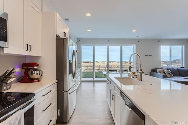 6645 Dry Fork Dr, Frederick, CO 80516 - kitchen with stainless steel appliances, a sink, wood finished floors, white cabinets, and recessed lighting