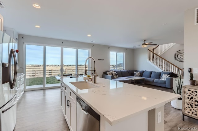 6645 Dry Fork Dr, Frederick, CO 80516 - kitchen featuring stainless steel appliances, a sink, light wood-type flooring, an island with sink, and recessed lighting