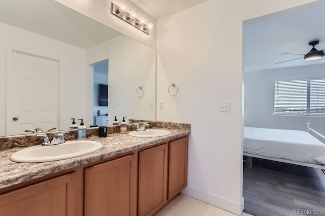 6645 Dry Fork Dr, Frederick, CO 80516 - ensuite bathroom with double vanity, baseboards, ceiling fan, and wood finished floors