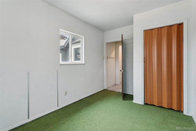 unfurnished bedroom with a closet, carpet, and baseboards