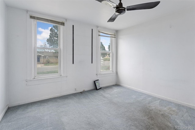 carpeted spare room with baseboards, ceiling fan, and a healthy amount of sunlight