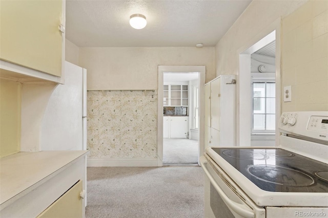 kitchen with light countertops, carpet, and electric stove
