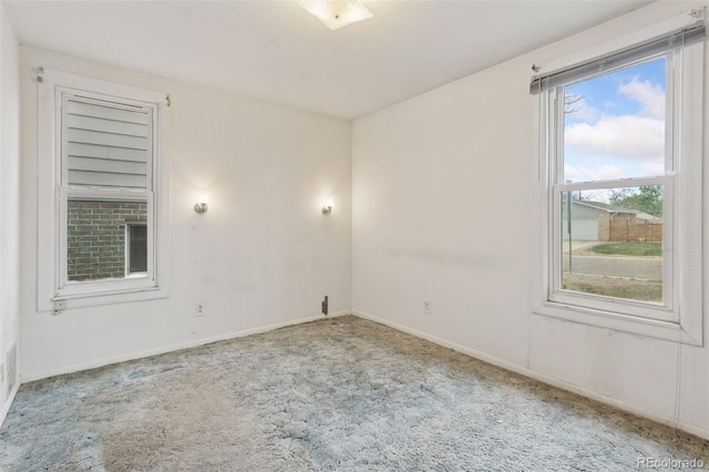 carpeted spare room featuring baseboards