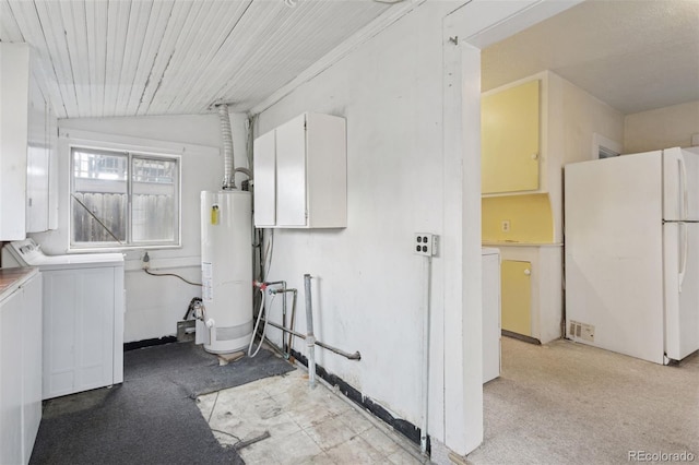 washroom featuring washing machine and clothes dryer, water heater, and cabinet space
