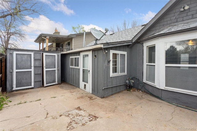view of home's exterior featuring a patio, board and batten siding, and roof with shingles
