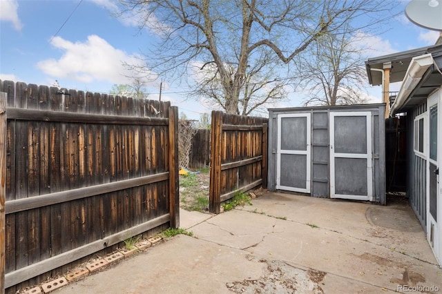 view of patio featuring a fenced backyard, an outdoor structure, and a storage shed