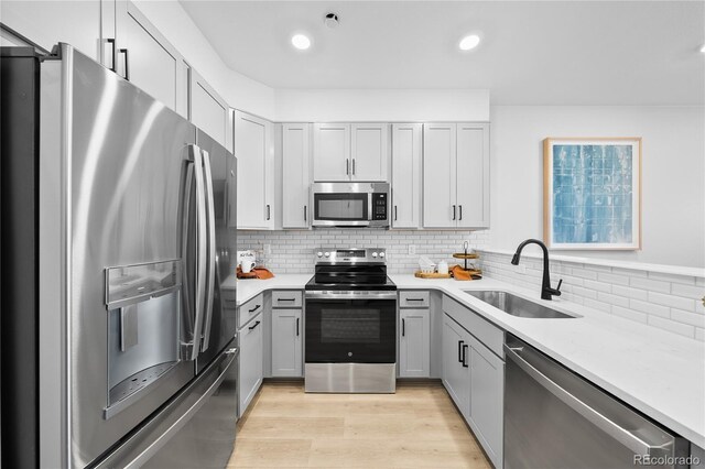 17137 W 91st Ln, Arvada, CO 80007 - kitchen featuring stainless steel appliances, a sink, light wood-style flooring, gray cabinetry, and recessed lighting