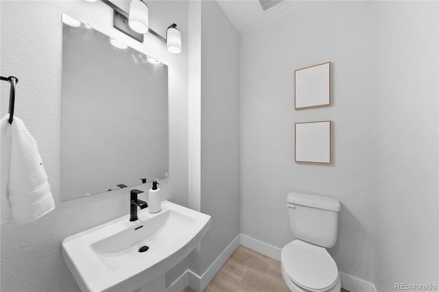 17137 W 91st Ln, Arvada, CO 80007 - bathroom with a sink, wood finished floors, toilet, and baseboards
