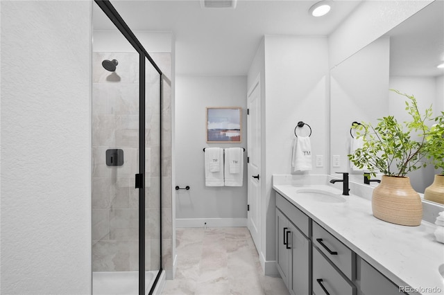 17137 W 91st Ln, Arvada, CO 80007 - bathroom featuring a shower stall, vanity, baseboards, and marble look tiles