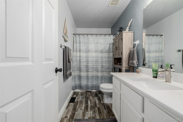 bathroom featuring toilet, vanity, curtained shower, and hardwood / wood-style flooring