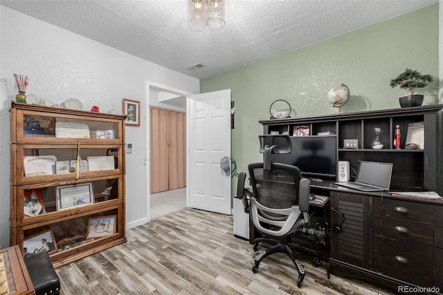 office space with light wood-type flooring and a textured ceiling