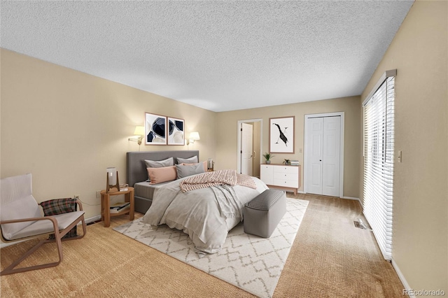 9183 W Cedar Dr Unit 2, Lakewood, CO 80226 - bedroom featuring a textured ceiling, light carpet, a closet, and baseboards
