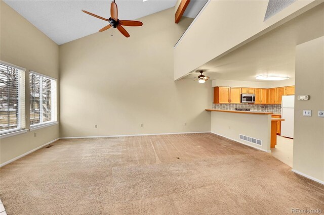 9183 W Cedar Dr Unit 2, Lakewood, CO 80226 - unfurnished living room featuring a ceiling fan, high vaulted ceiling, light carpet, baseboards, and beam ceiling