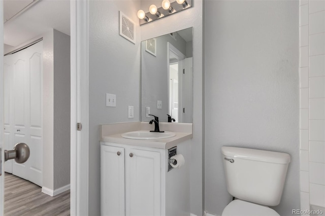 bathroom featuring hardwood / wood-style flooring, vanity, and toilet