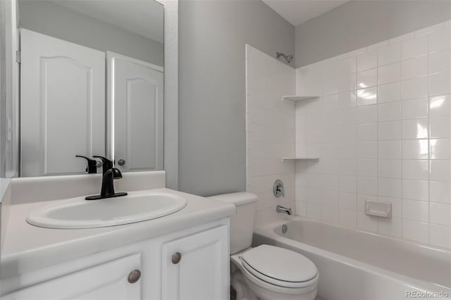 full bathroom featuring tiled shower / bath combo, toilet, and vanity