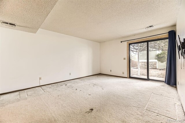 empty room featuring carpet flooring, a textured ceiling, and baseboards