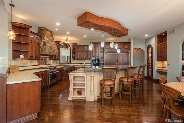 kitchen featuring arched walkways, dark wood-type flooring, visible vents, high quality appliances, and open shelves