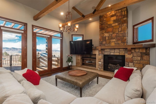 living area with a mountain view, beam ceiling, a fireplace, and wood finished floors