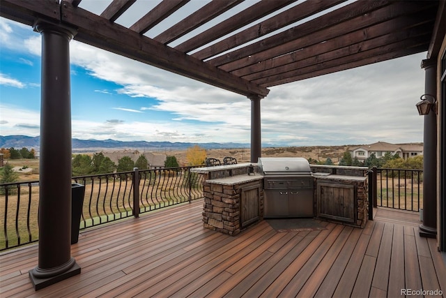 wooden terrace with a mountain view, a pergola, and area for grilling