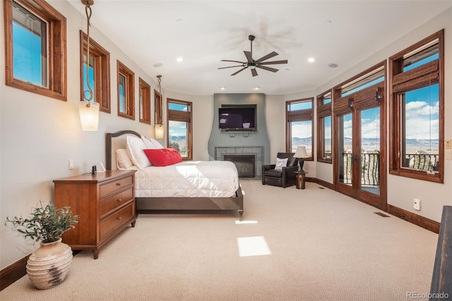 bedroom with access to exterior, recessed lighting, a glass covered fireplace, light carpet, and baseboards