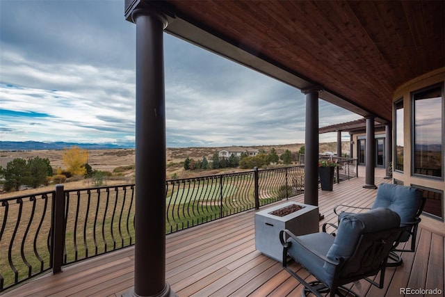 wooden terrace featuring an outdoor fire pit and a mountain view