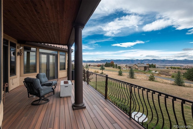 wooden deck with a rural view and a mountain view