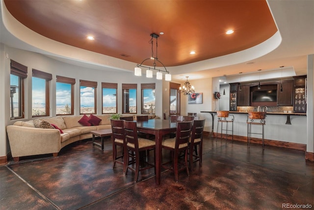 dining area featuring finished concrete flooring, baseboards, a tray ceiling, and recessed lighting