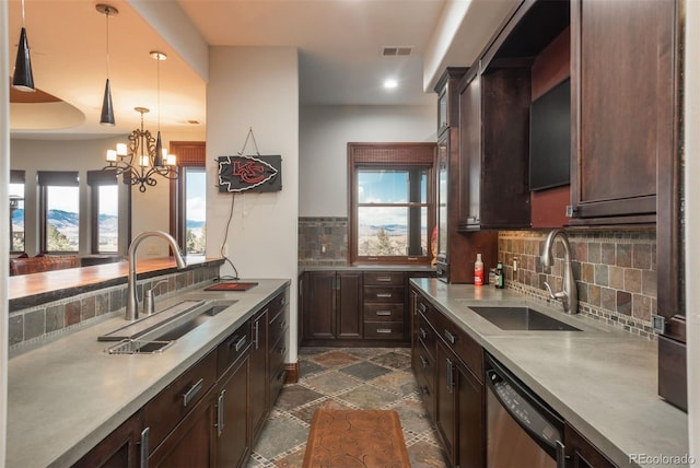 kitchen featuring stainless steel dishwasher, stone tile floors, visible vents, and a sink