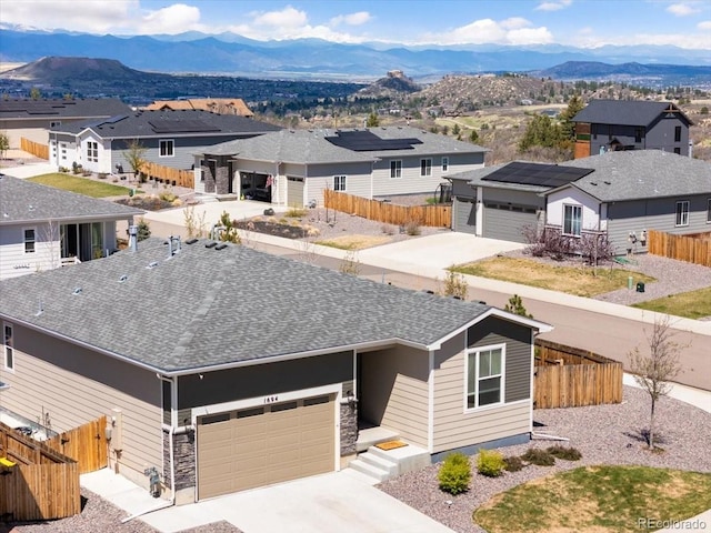 view of front facade featuring a garage, a mountain view, a residential view, and concrete driveway