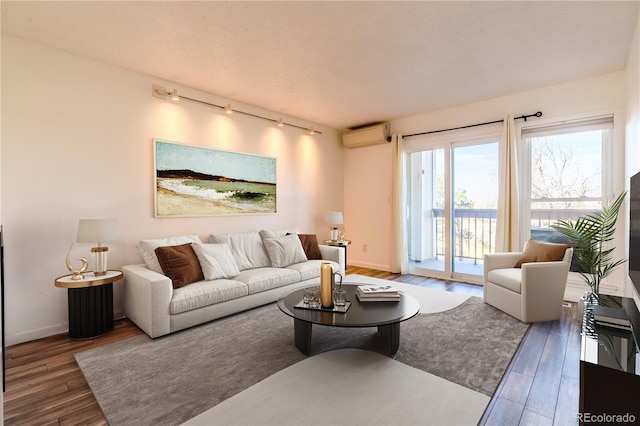 living room with dark hardwood / wood-style floors and a wall unit AC