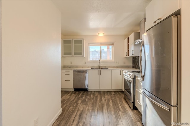 kitchen with dark hardwood / wood-style flooring, sink, white cabinets, and appliances with stainless steel finishes