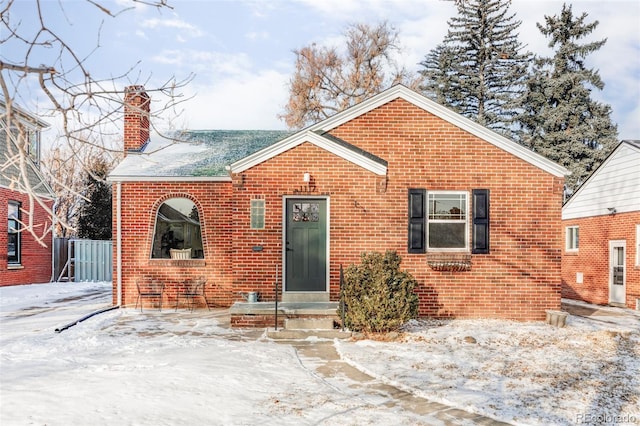 bungalow with brick siding and a chimney