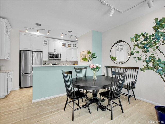 2716 W Greens Dr, Littleton, CO 80123 - dining area featuring rail lighting, light wood-style flooring, and baseboards
