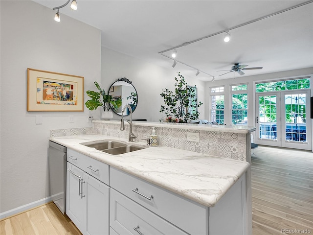 2716 W Greens Dr, Littleton, CO 80123 - kitchen featuring track lighting, a peninsula, stainless steel dishwasher, light wood-style flooring, and ceiling fan