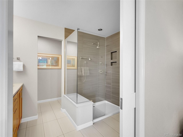 2716 W Greens Dr, Littleton, CO 80123 - bathroom featuring a walk in shower, vanity, tile patterned floors, and baseboards