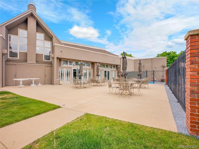 2716 W Greens Dr, Littleton, CO 80123 - rear view of house featuring stucco siding, a patio, and a chimney