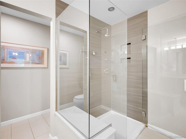 2716 W Greens Dr, Littleton, CO 80123 - bathroom featuring tile patterned flooring, a stall shower, toilet, and baseboards