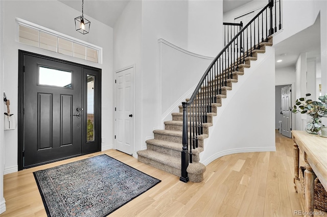 12408 W 83rd Ave, Arvada, CO 80005 - foyer with high vaulted ceiling, stairway, light wood finished floors, and baseboards