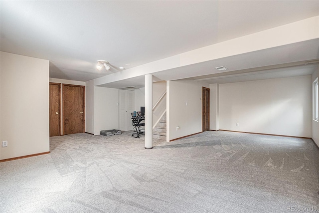 finished basement featuring carpet floors, stairs, and baseboards