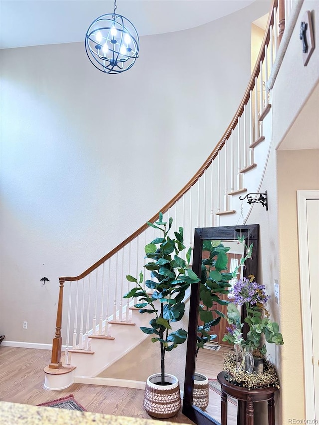 stairs with an inviting chandelier and hardwood / wood-style floors