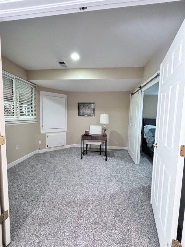 interior space with a barn door and carpet