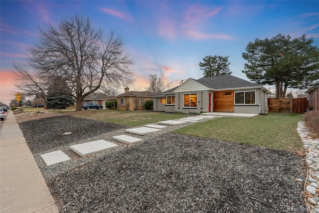 view of front facade featuring fence and a yard