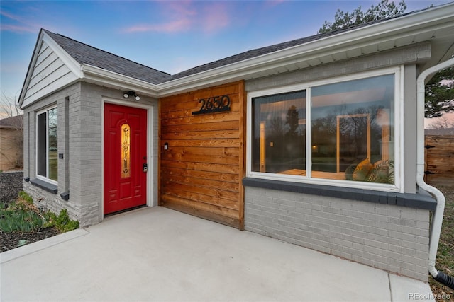 doorway to property with brick siding