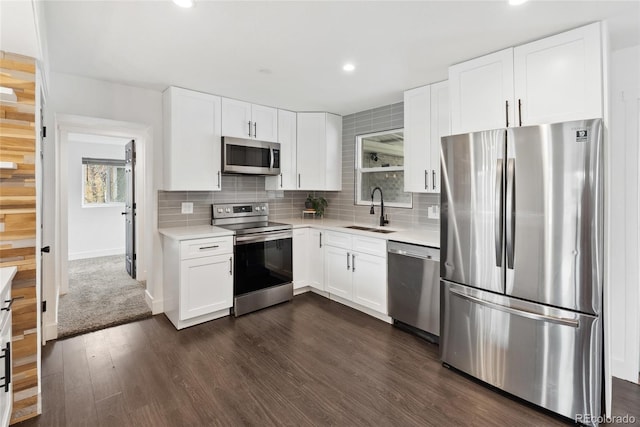 kitchen with light countertops, a sink, backsplash, and appliances with stainless steel finishes