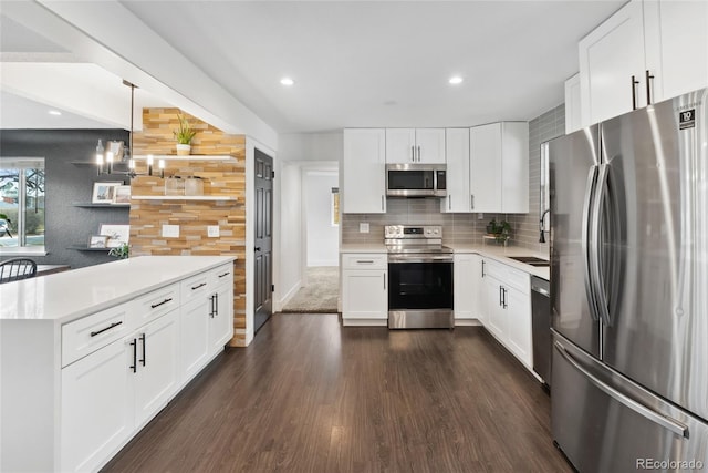 kitchen featuring light countertops, stainless steel appliances, a sink, dark wood-style floors, and backsplash